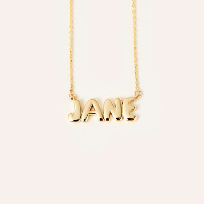 Collier avec le nom inscrit en lettres bulles en or 14 carats.