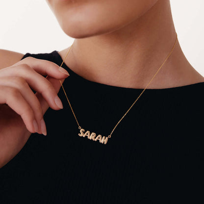 Collier avec le nom inscrit en lettres bulles en or 14 carats.