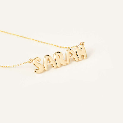 Collier avec le nom inscrit en lettres bulles en or 14 carats.