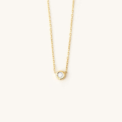 Collier de naissance solitaire en or 14 carats avec lunette sertie d'une pierre précieuse.